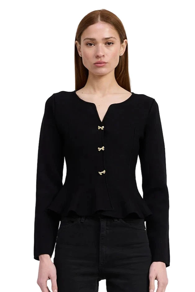 Woman wearing a black cardigan with gold buttons on a white background