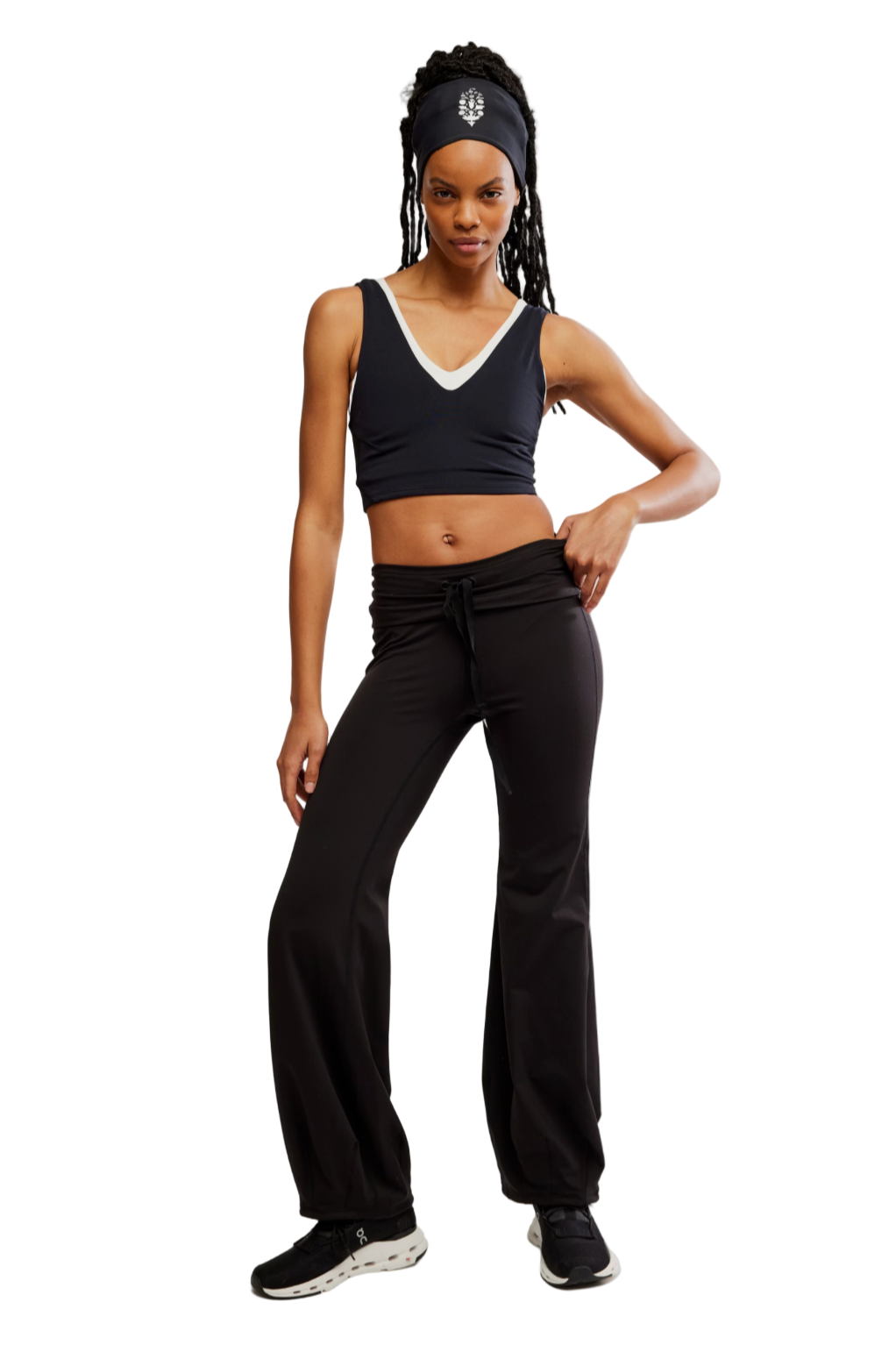 Woman wearing a black tank top and black pants on a white background