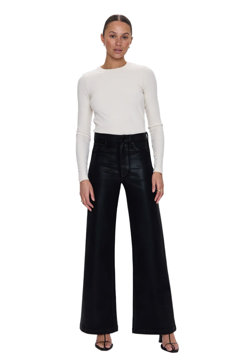 Woman wearing a white sweater and Pistola black high-waisted denim.