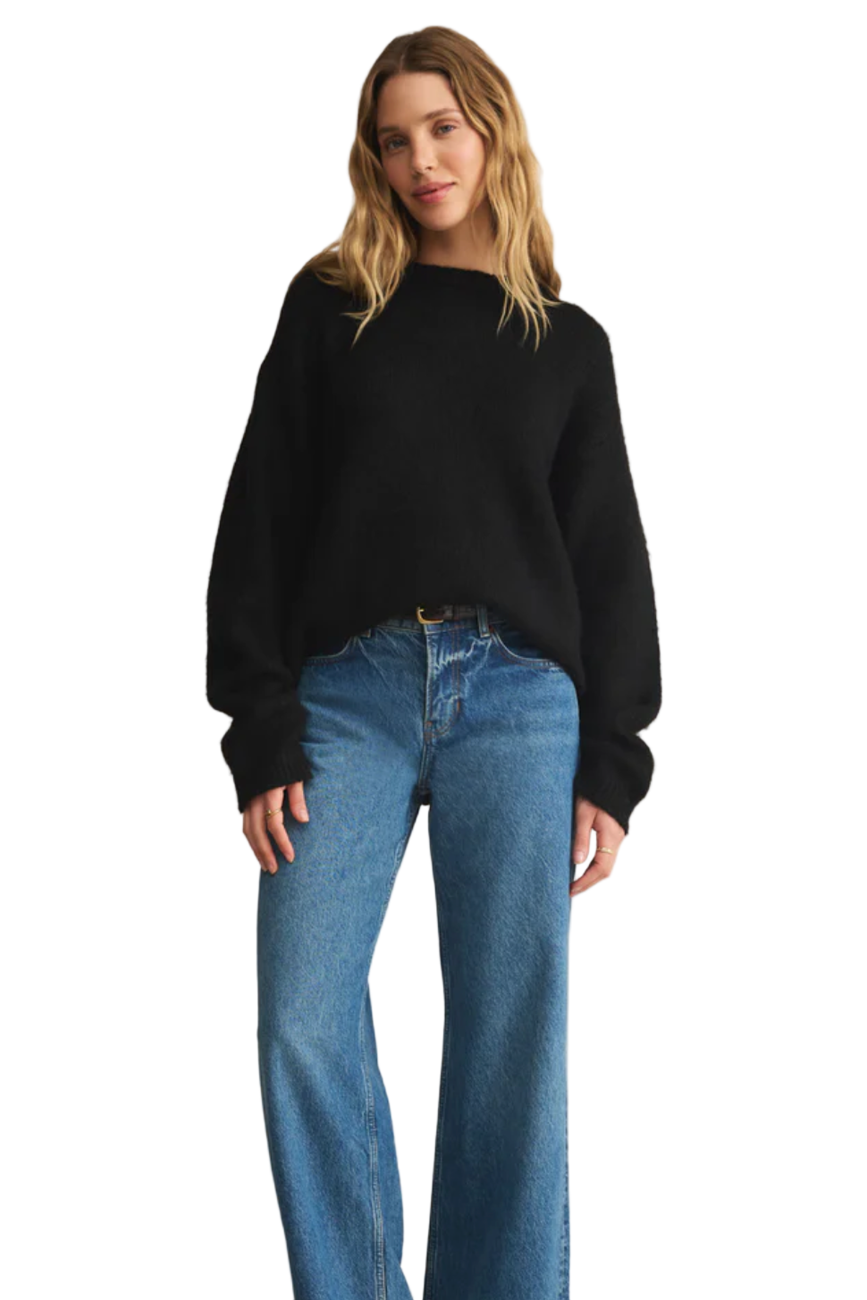 Woman wearing a black sweater and blue jeans on a beige background