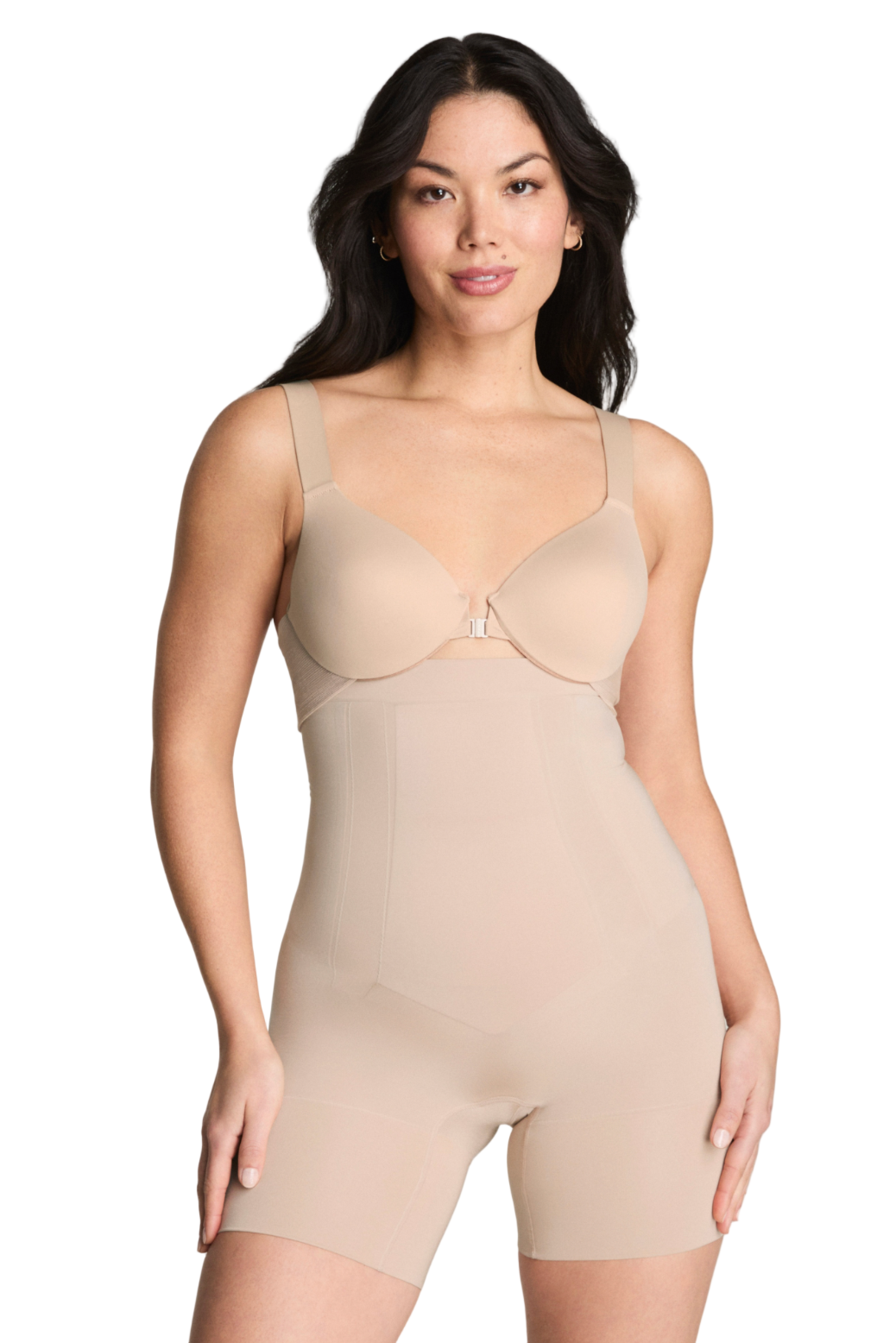 Woman wearing a beige shapewear bodysuit against a gray background