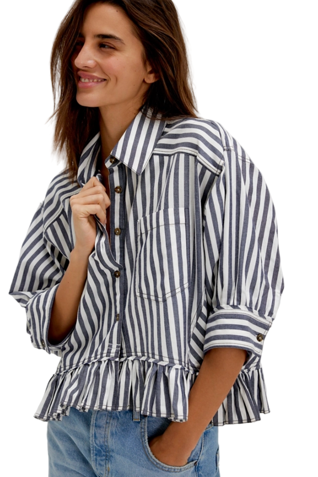 Woman wearing a blue and white striped shirt with rolled-up sleeves on a plain background