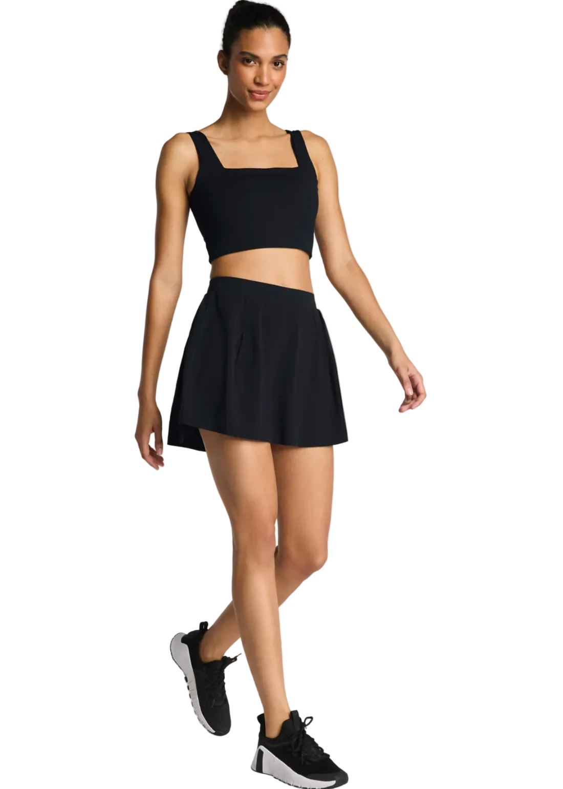 Woman wearing the SPANXshape™ BoostUp Pleated Skort, 14-inch length, a flattering pleated active skort with polished sporty style.