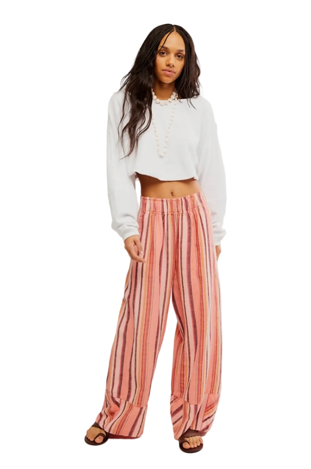 Woman wearing Free People Day’s End Linen Striped Pull-On Pants in Coral Combo with relaxed wide-leg fit and lightweight striped linen fabric.