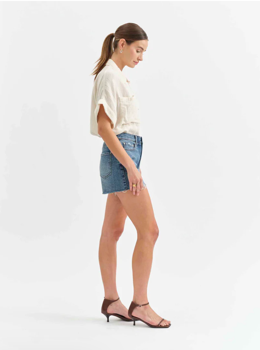 Woman wearing a white top and denim skirt on a white background
