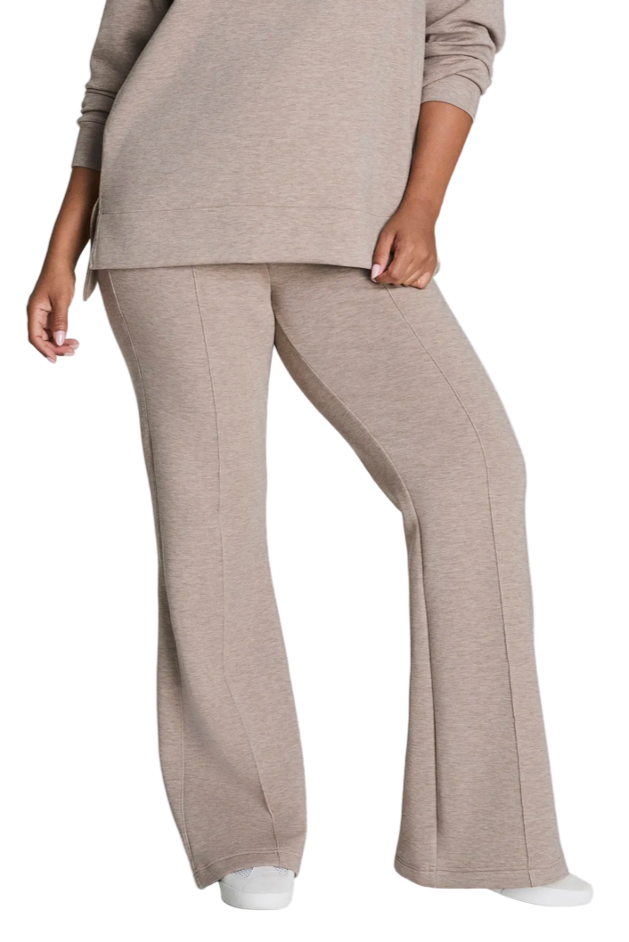 Person wearing a beige lounge set on a white background