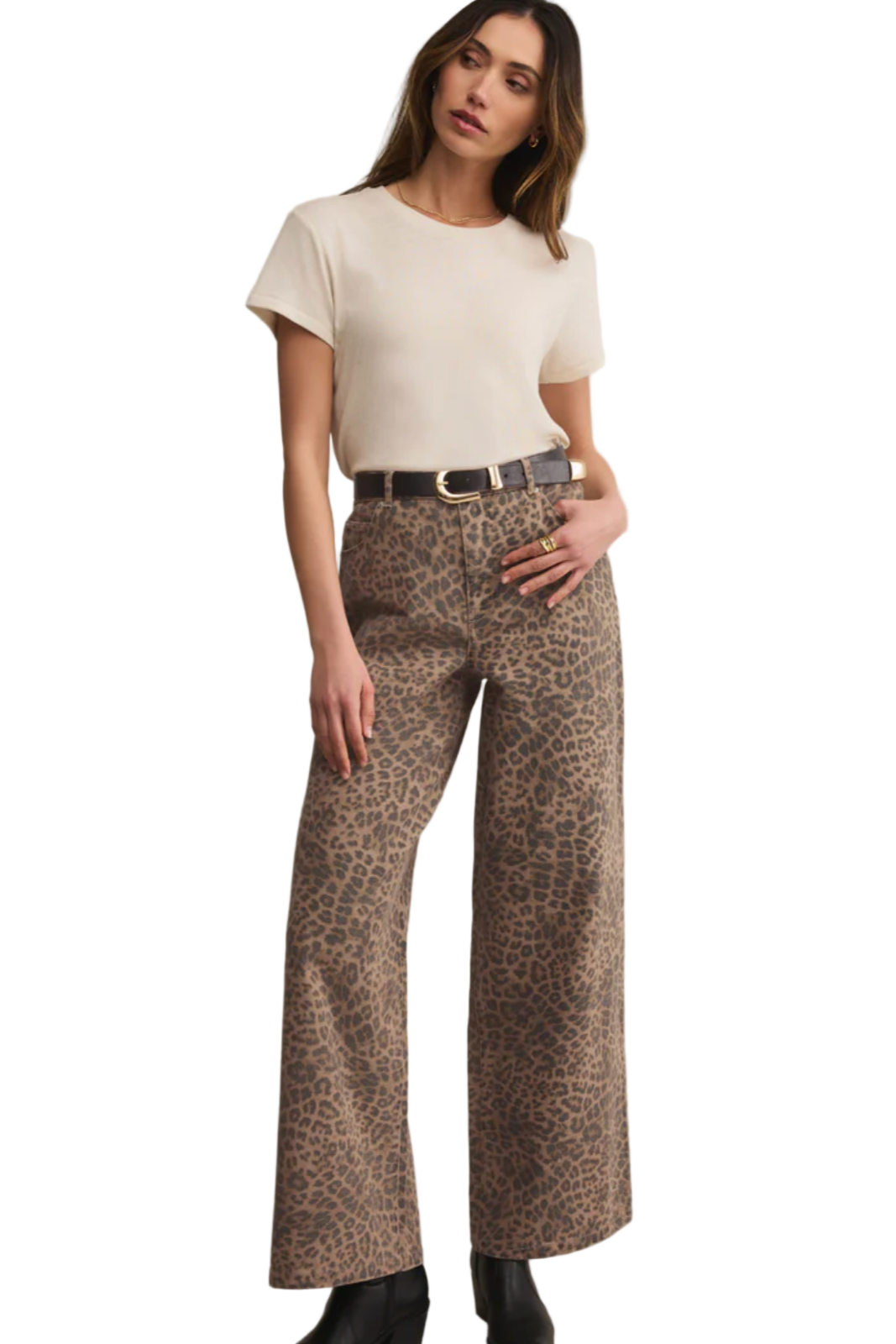 Woman wearing a white top and leopard print pants on a beige background