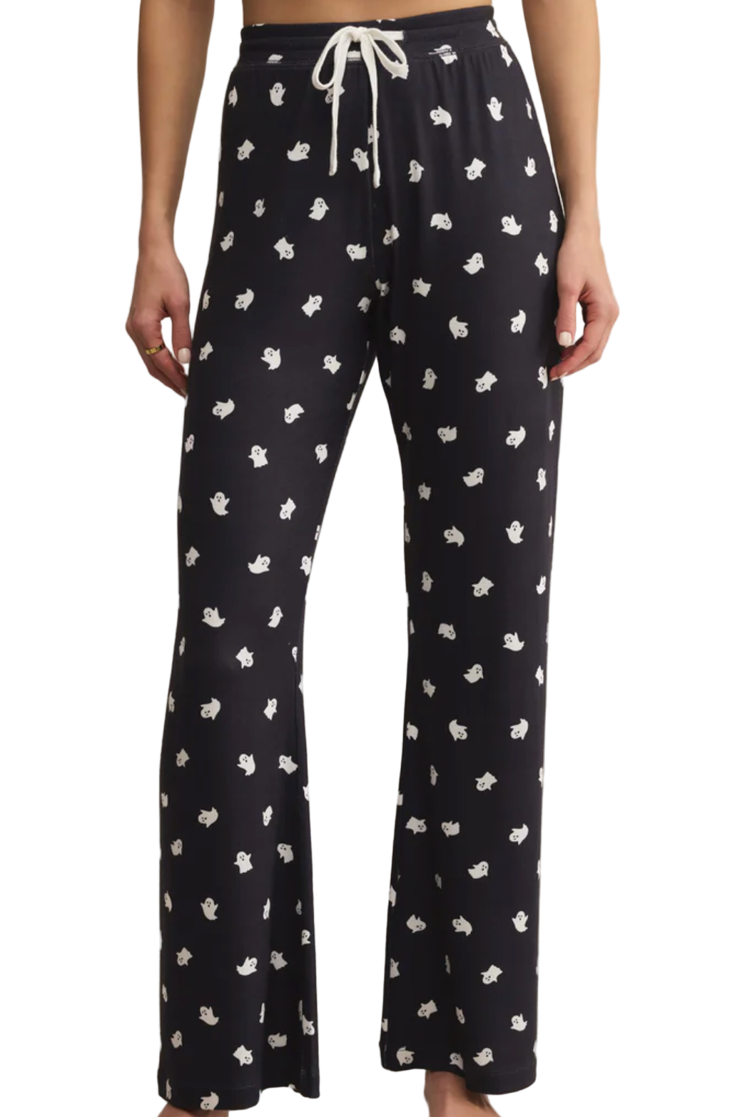 Black pajama pants with white floral pattern worn by a person on a white background
