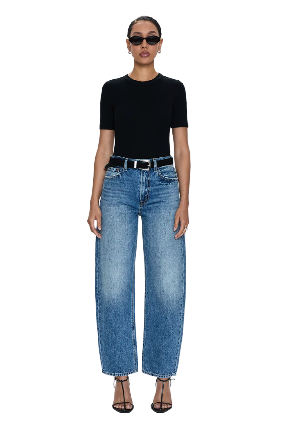 Person wearing a black top and blue jeans on a white background