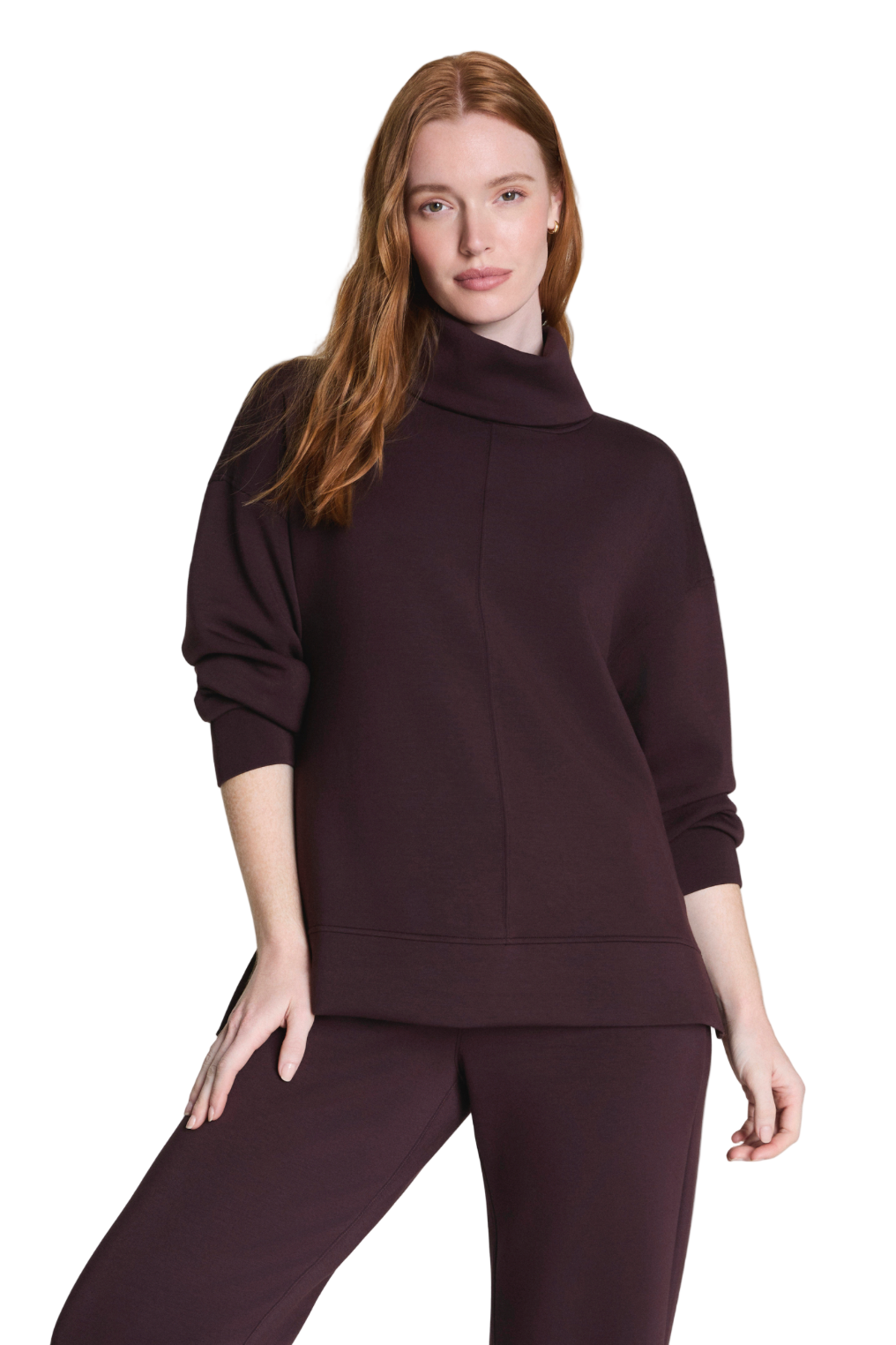 Woman wearing a dark brown outfit on a light gray background