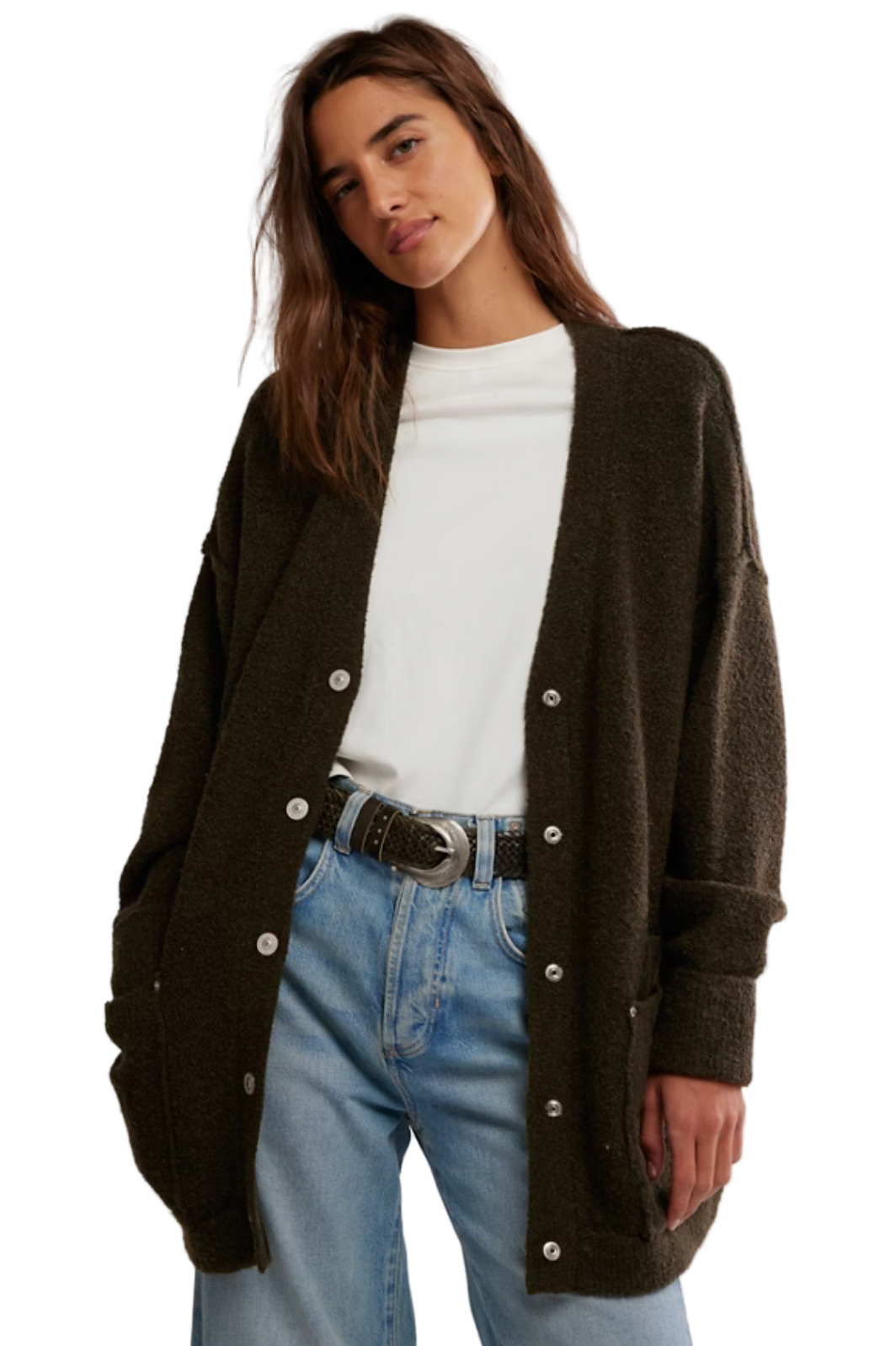 Woman wearing a dark green cardigan with button details, white shirt, and light blue jeans on a plain background.