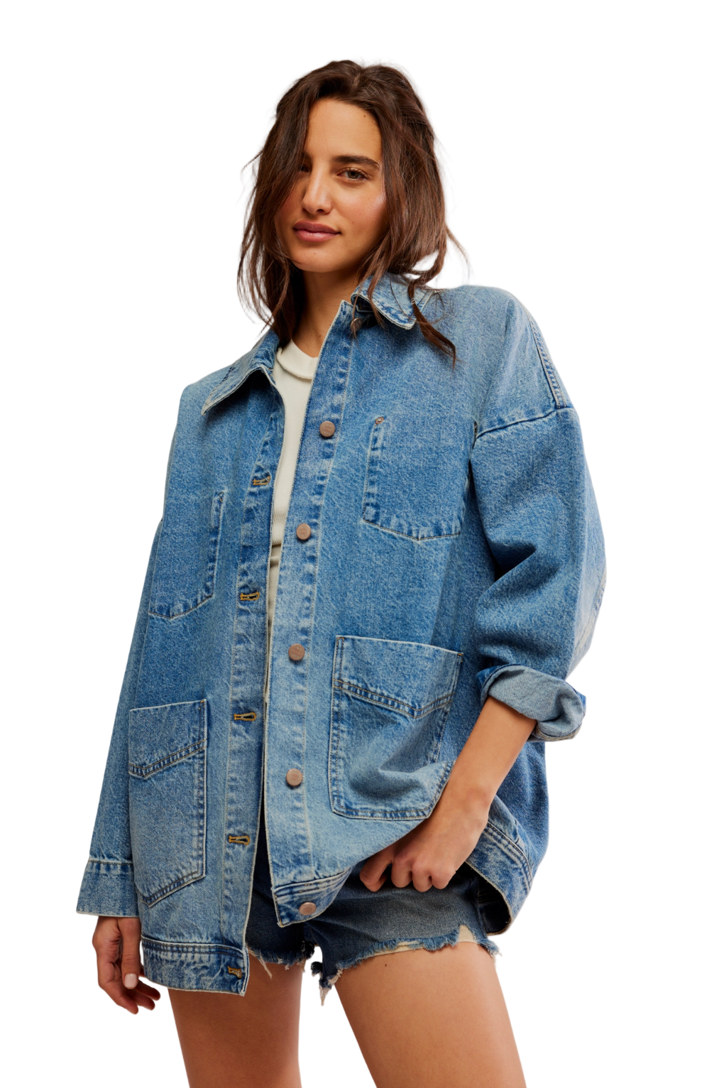 Woman wearing a denim jacket and shorts on a plain background