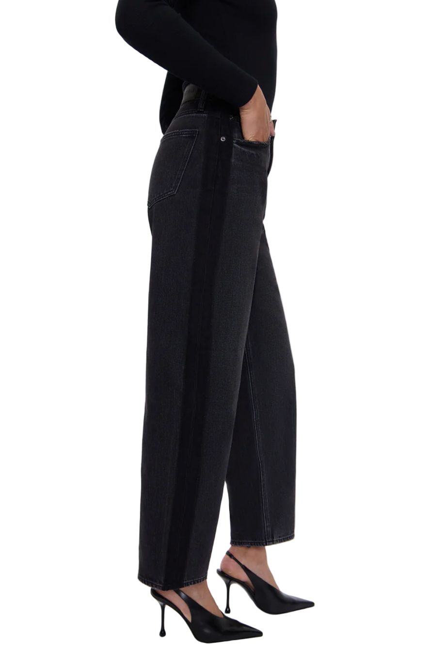 Person wearing black high-waisted jeans and black high-heeled shoes on a white background