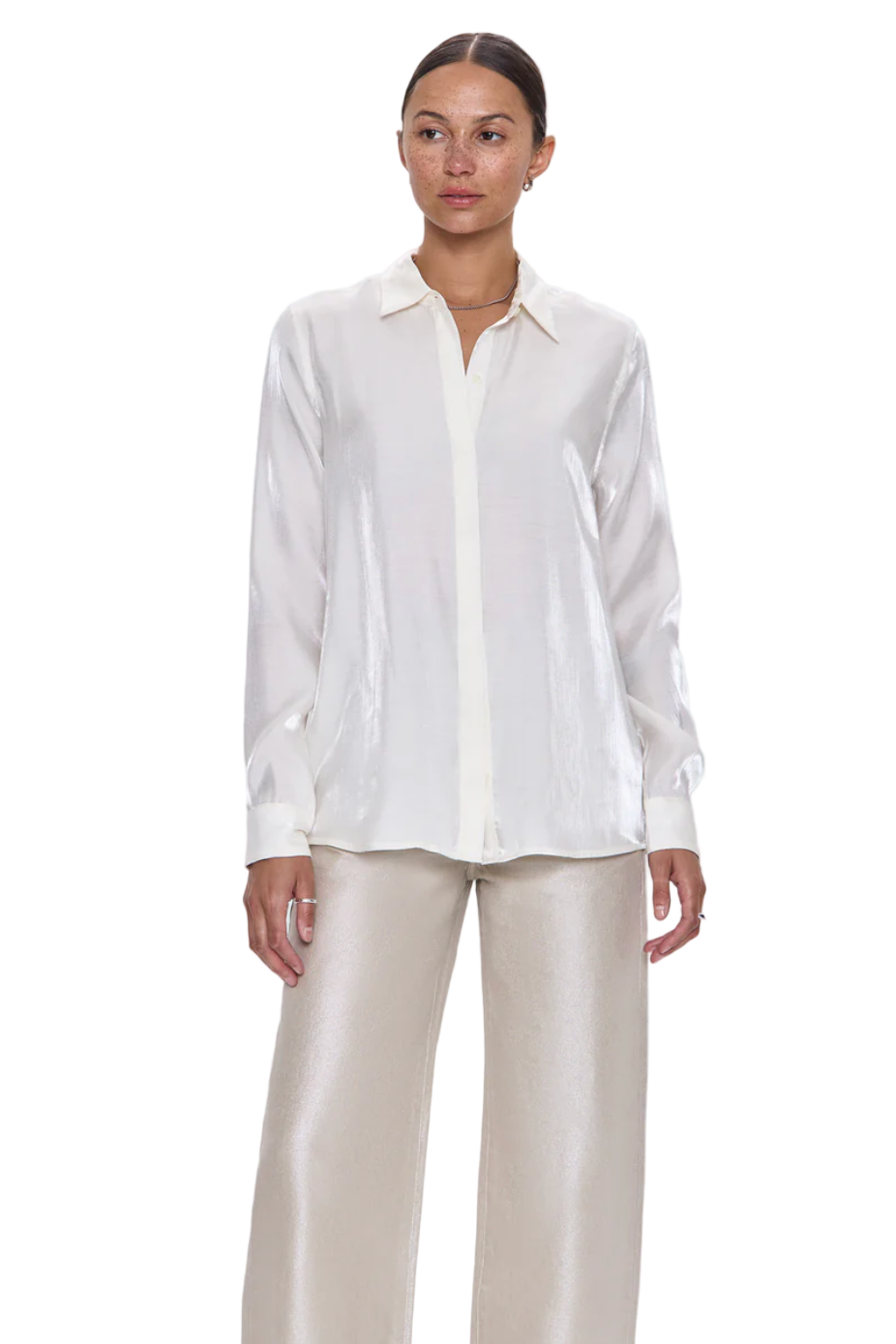 Woman wearing a white blouse and beige pants on a light gray background