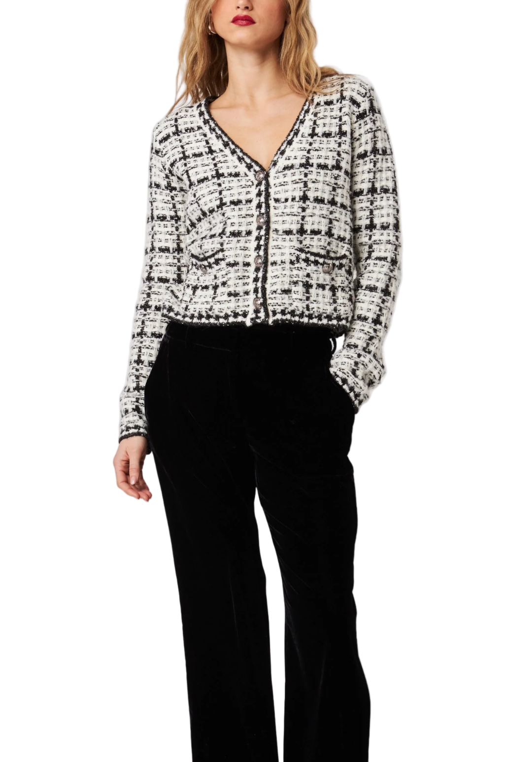 Woman wearing a black and white patterned blouse with black pants on a white background