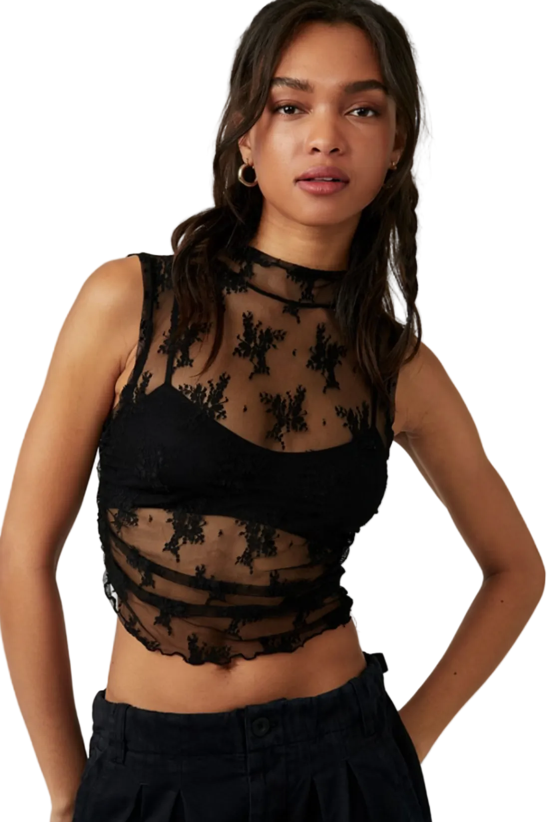Woman wearing a black sheer top with floral patterns on a white background