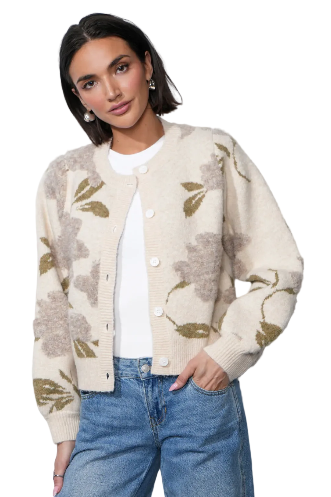 Woman wearing a patterned cardigan and jeans against a plain background