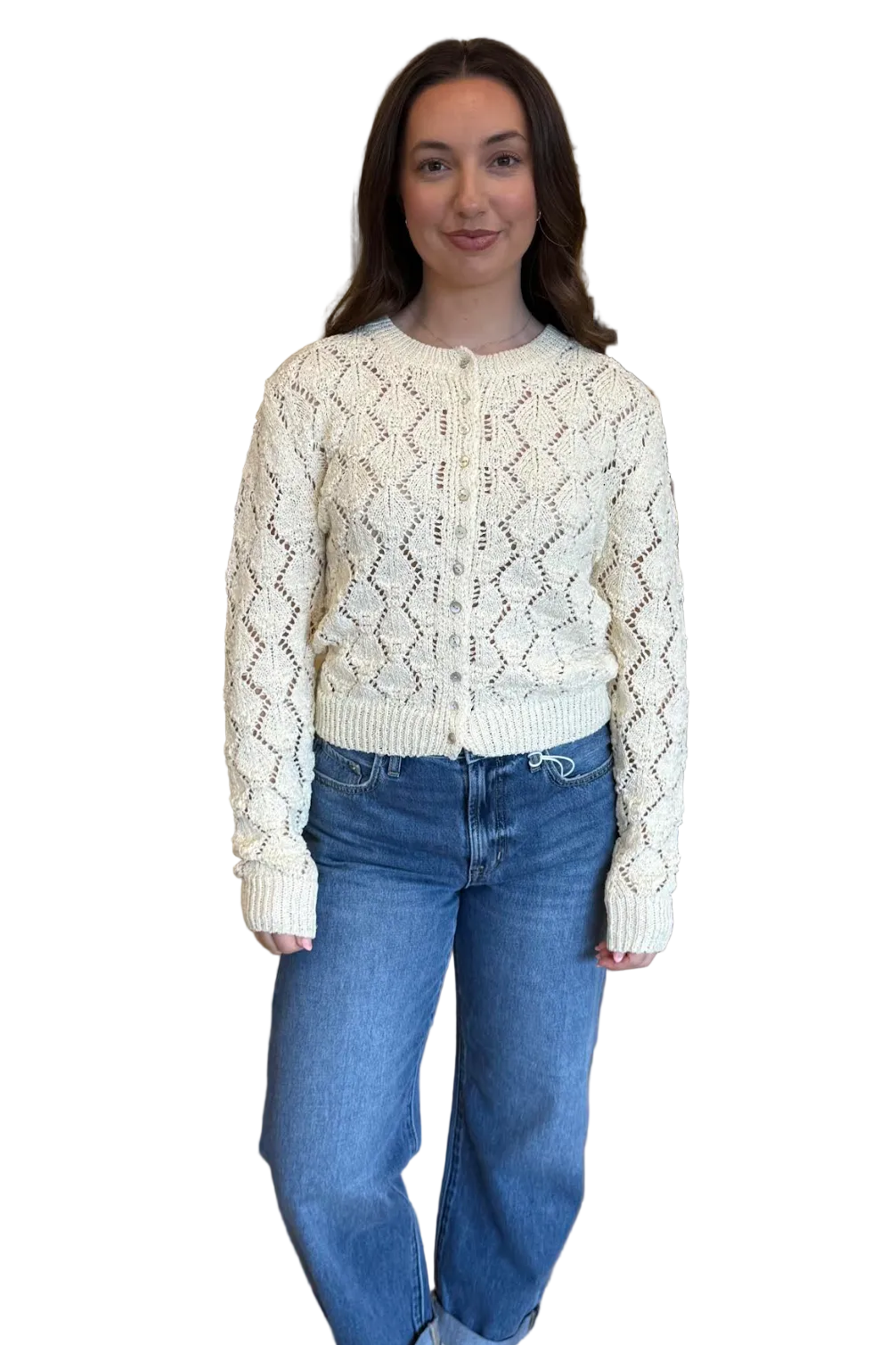 Woman wearing a cream knitted sweater and blue jeans on a white background