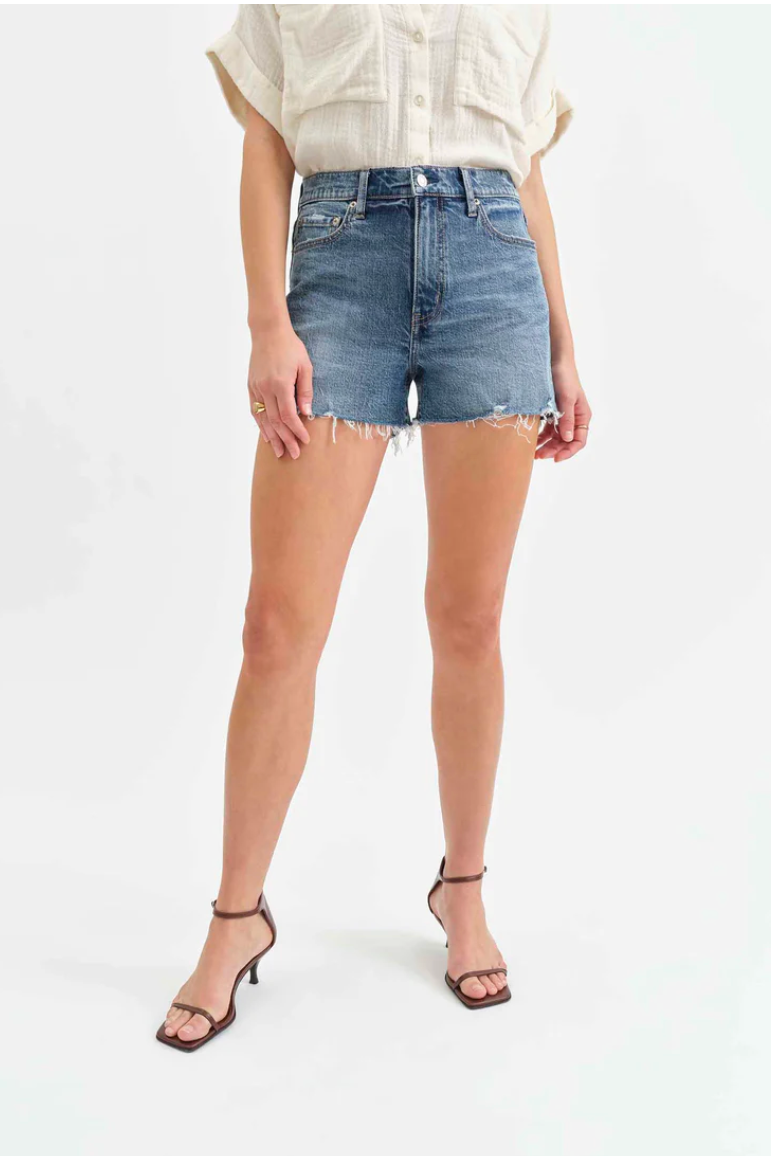 Person wearing light blue denim shorts on a white background