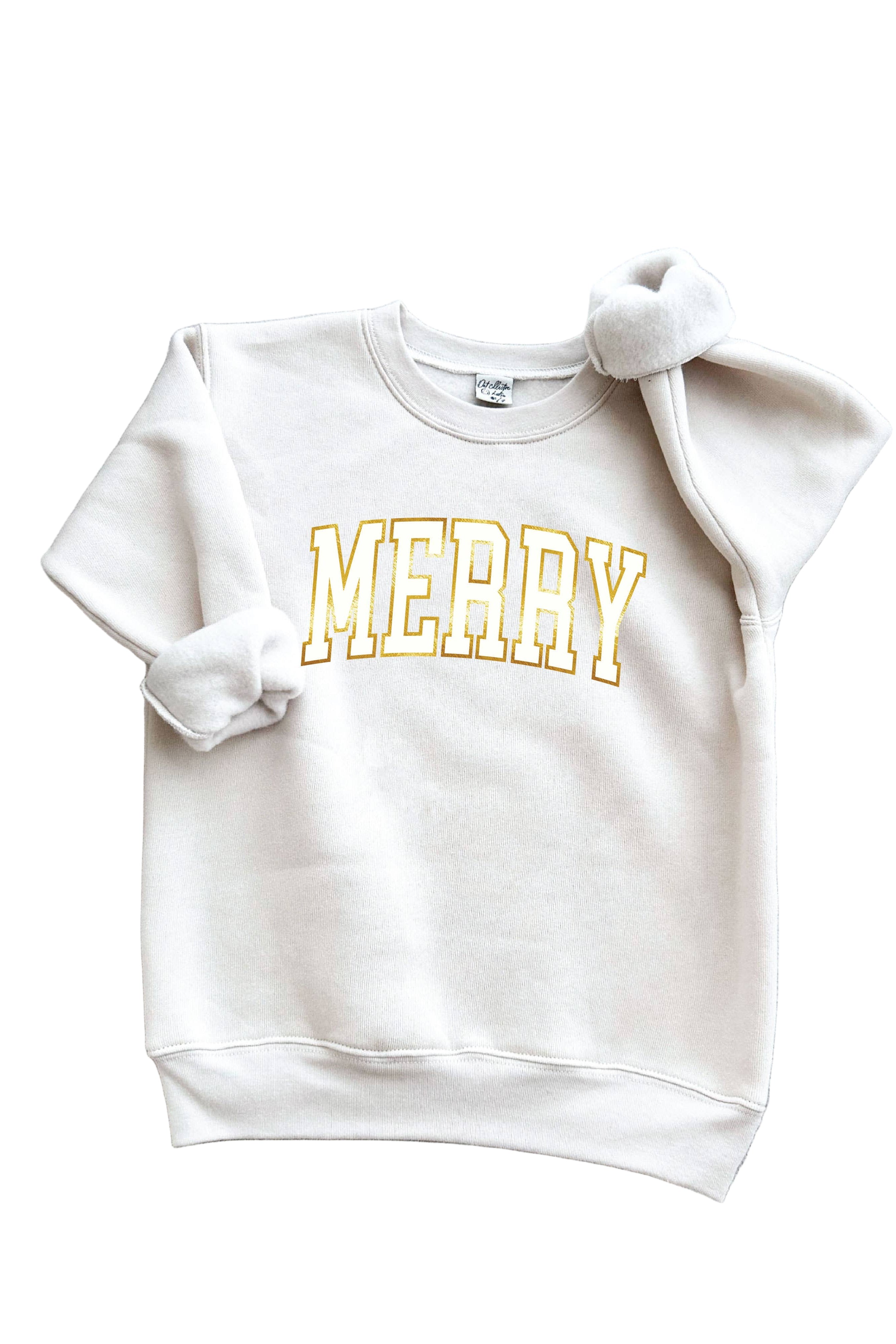Oat Collective white sweatshirt with 'MERRY' in gold foil on a gray surface